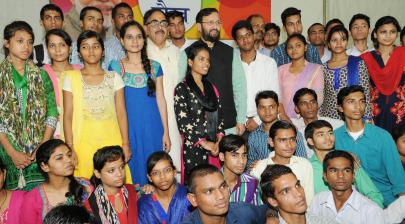 HRM in a group photograph with the students, who cleared XII with high marks and got admission to reputed colleges